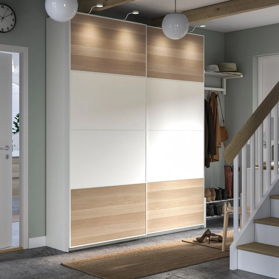 Modern hallway sleek, white and wood-toned PAX wardrobe, stylish lighting, and organised entry.