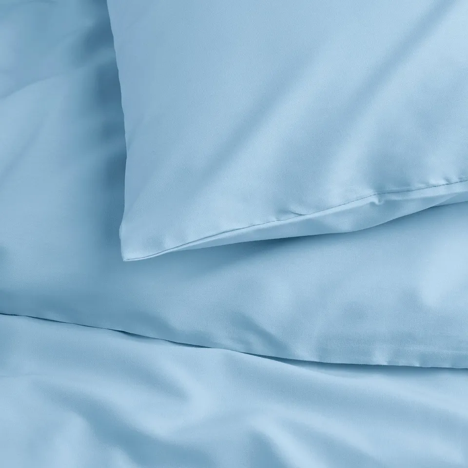 Light blue duvet cover set, showing smooth, wrinkle-resistant fabric with visible pop-button closure.