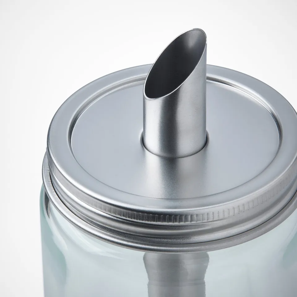Cylindrical glass bottle with stainless steel cap and spout. Lid screws on securely, pours controlled amount.
