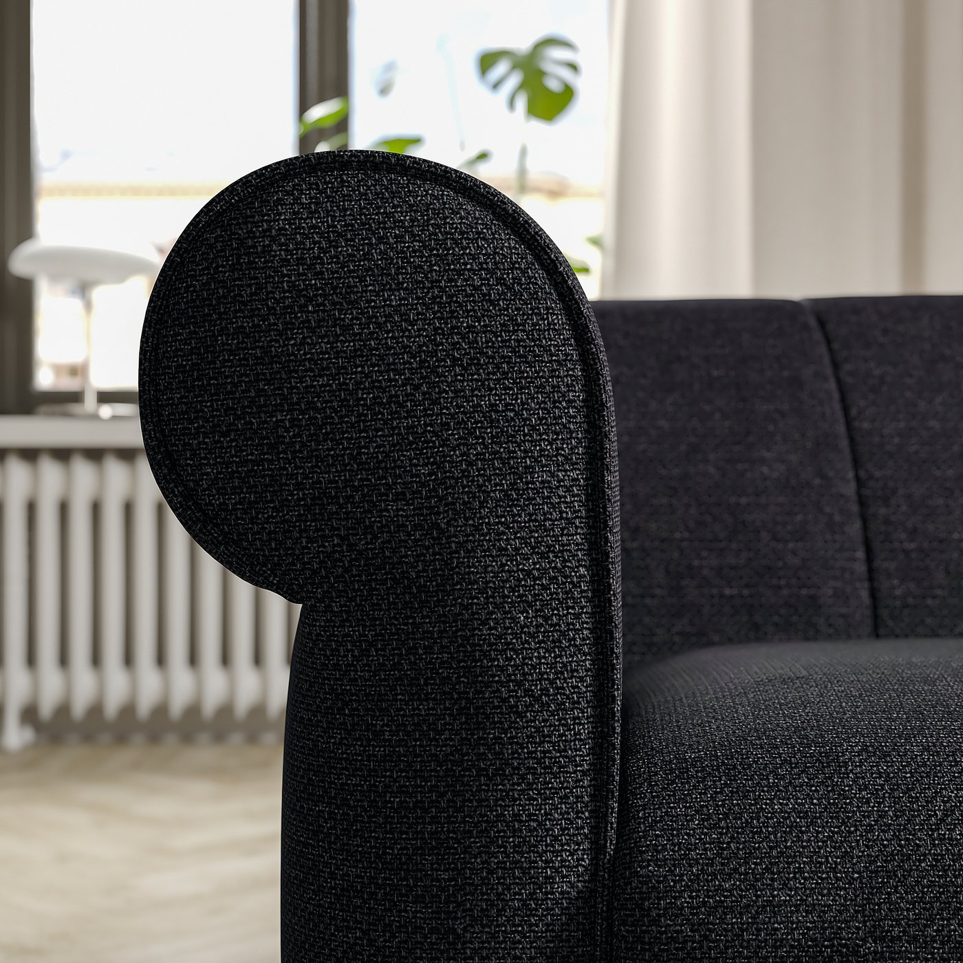 Black fabric sofa with rounded, inviting shapes, deep cushions, and classic design.