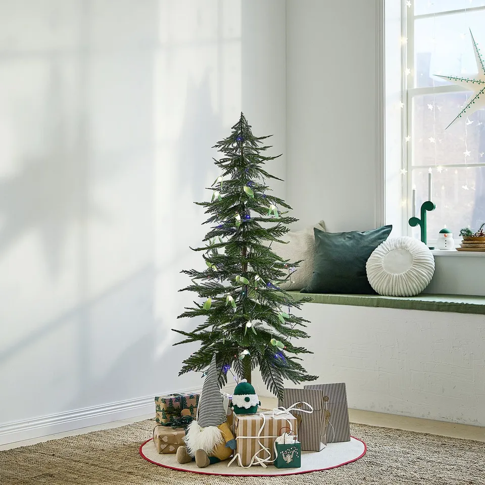 Christmas scene: decorated tree, santa, gifts, cosy window.