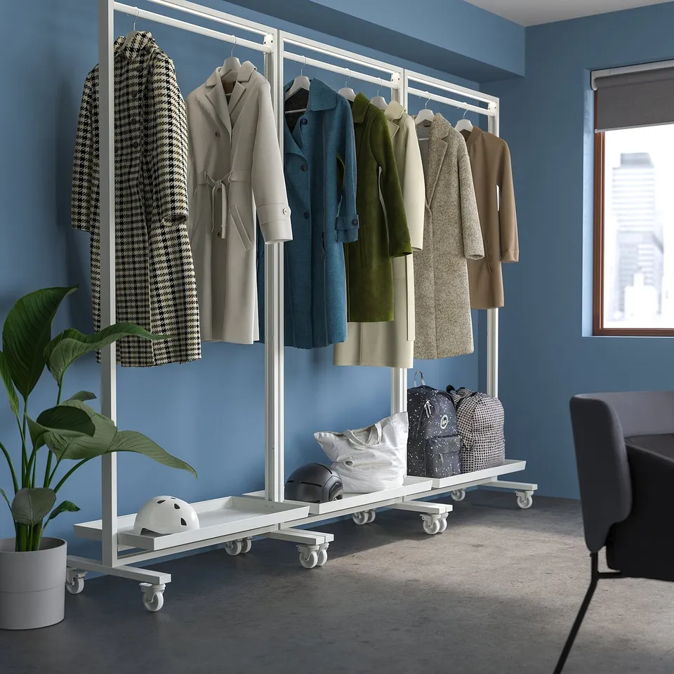 MITTZON mobile clothing rack with various coats and bags in blue walled room.