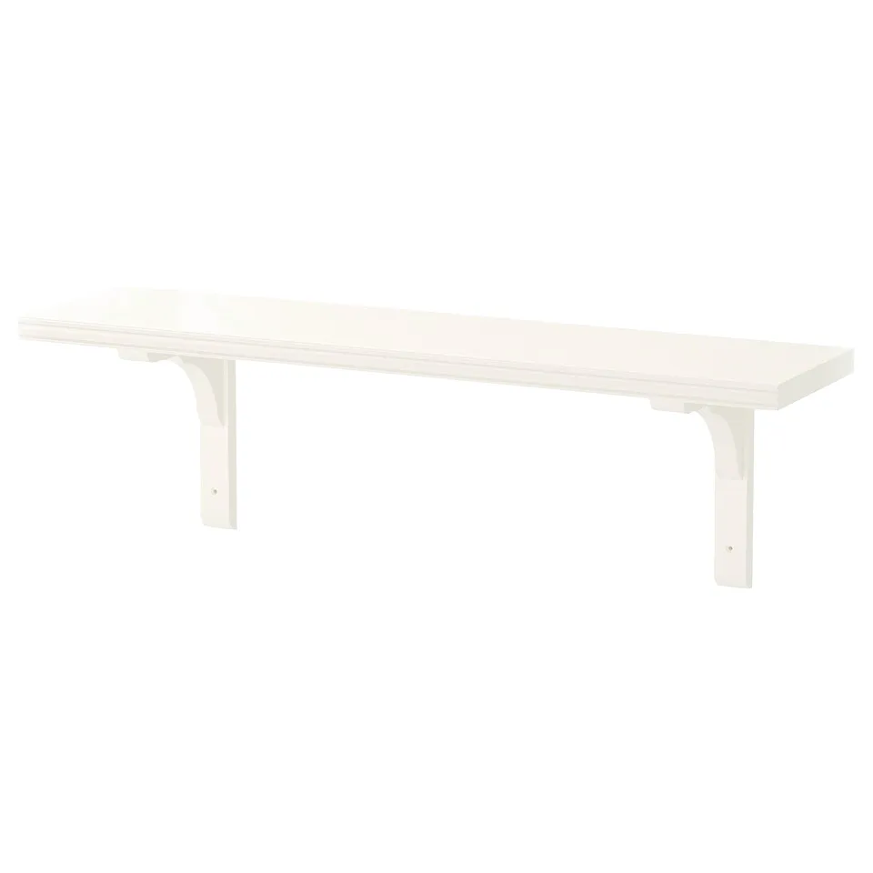 A white BERGSHULT wall shelf, featuring a smooth and bevelled edge design, supported by acrylic-painted fiberboard brackets.