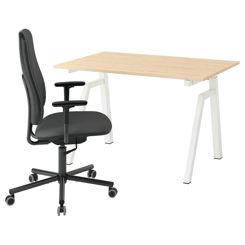 A modern home office setup with a light brown height-adjustable desk and a black office chair with armrests.