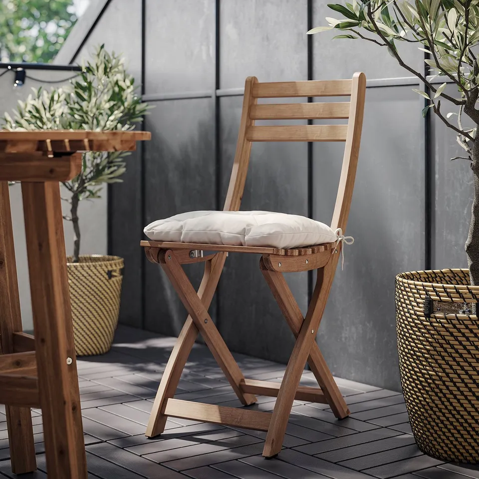 Natural wood, light beige cushion chair outdoors, simple design, grey tiled patio.