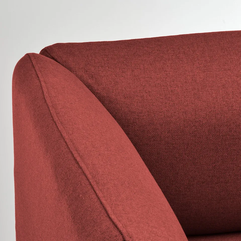 Red upholstered sofa corner, showing clean stitching and quality fabric.