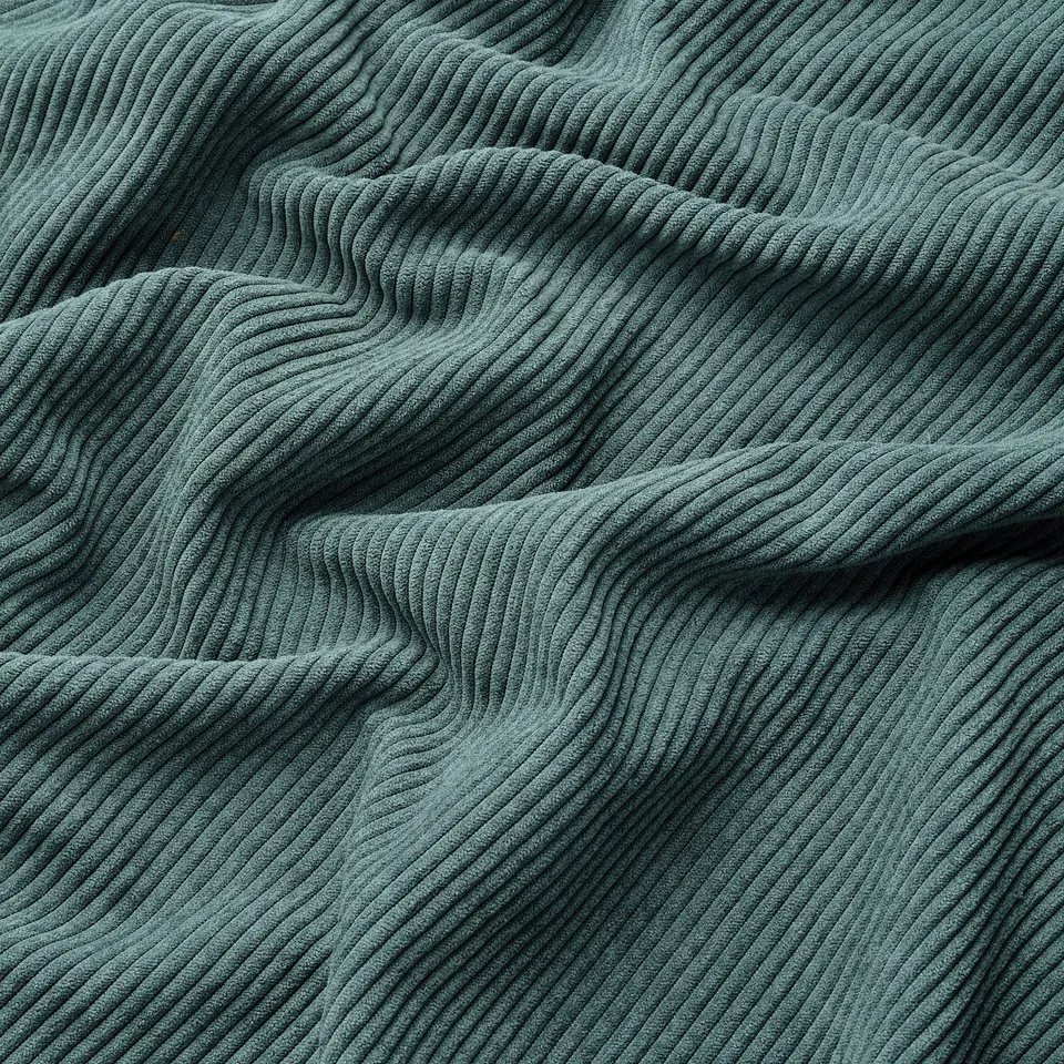 Green corduroy fabric texture; soft, durable,x-wale pattern; detailed, close-up view.