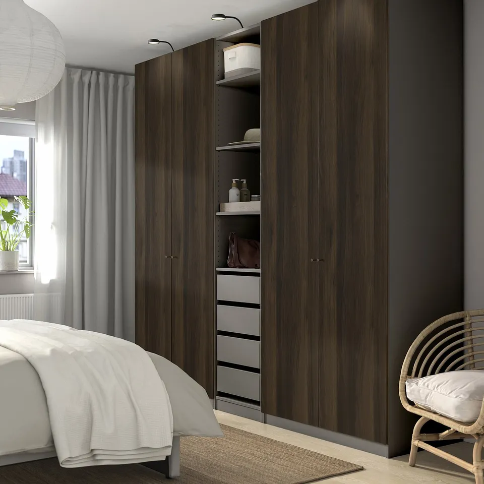 Modern bedroom with dark PAX wardrobe, bed, and grey curtains.