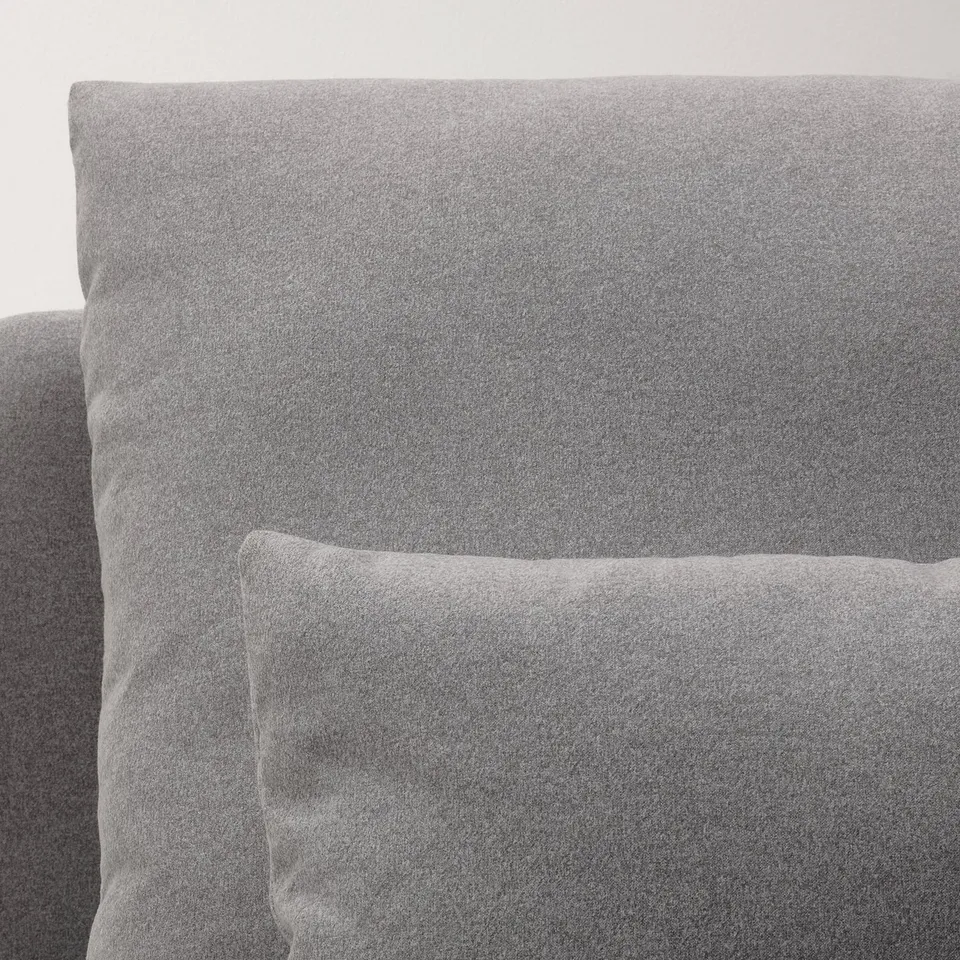 Modern sleek sofa with light grey fabric and high back.