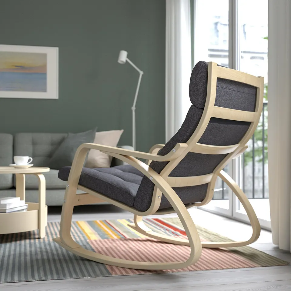 Modern rocking chair with curved wood frame and dark cushions in cosy living room.