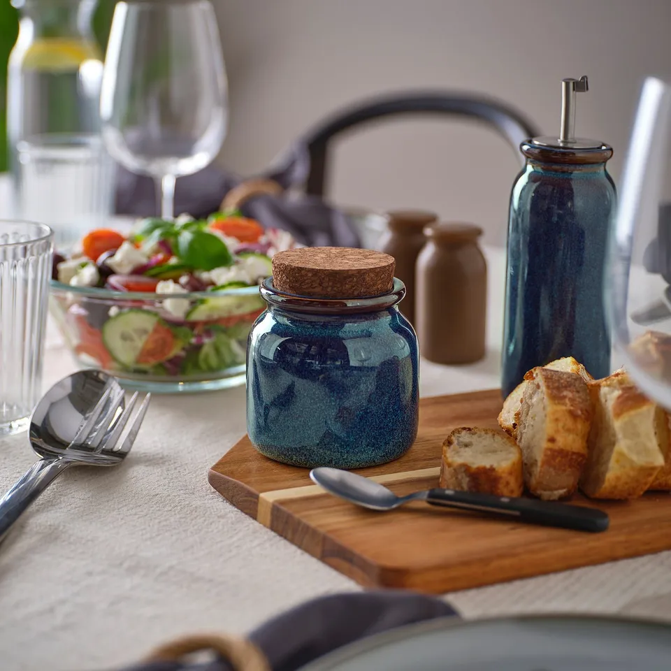 Stoneware jar with cork lid, displayed with food.