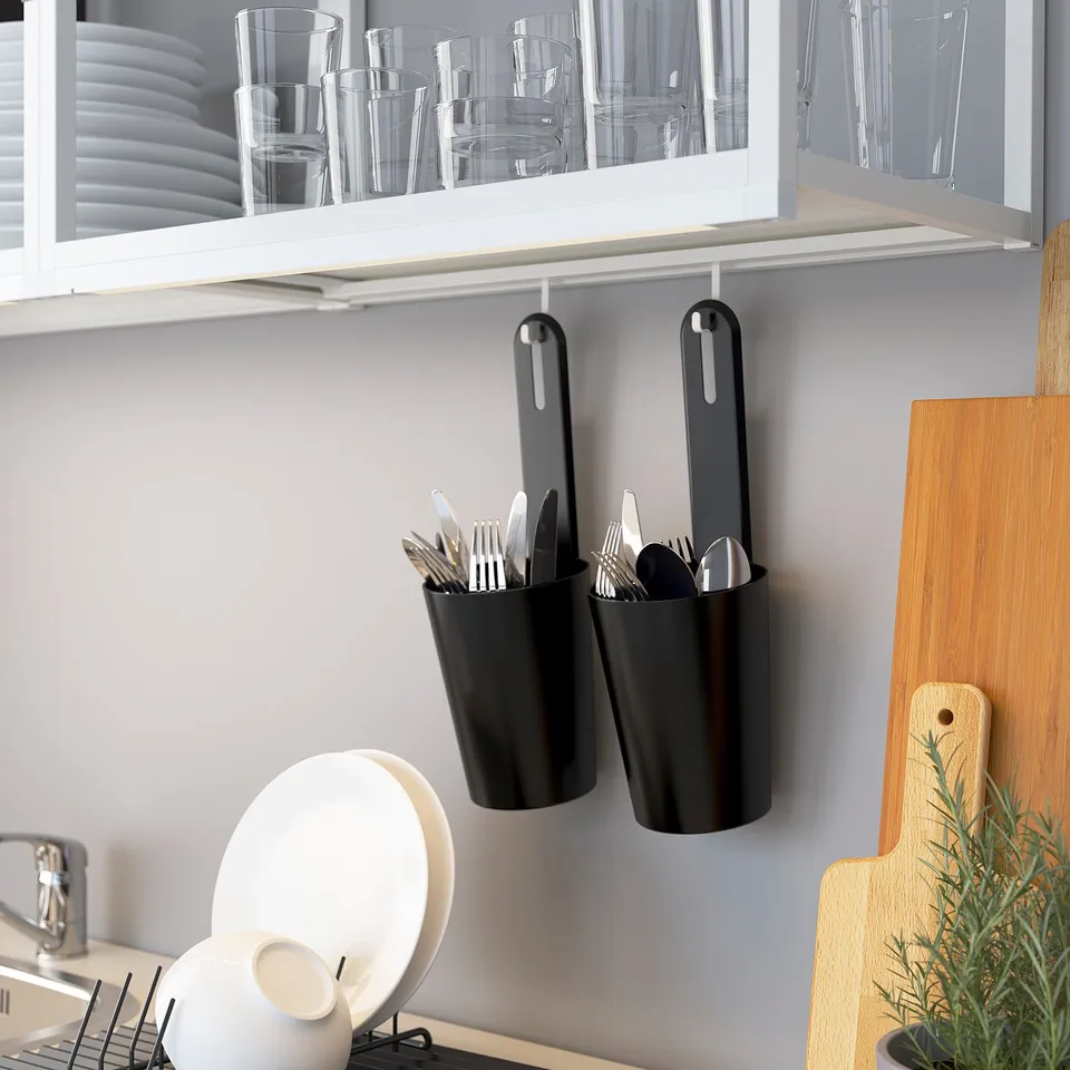 Kitchen shelf with hanging utensil holders and glasses.