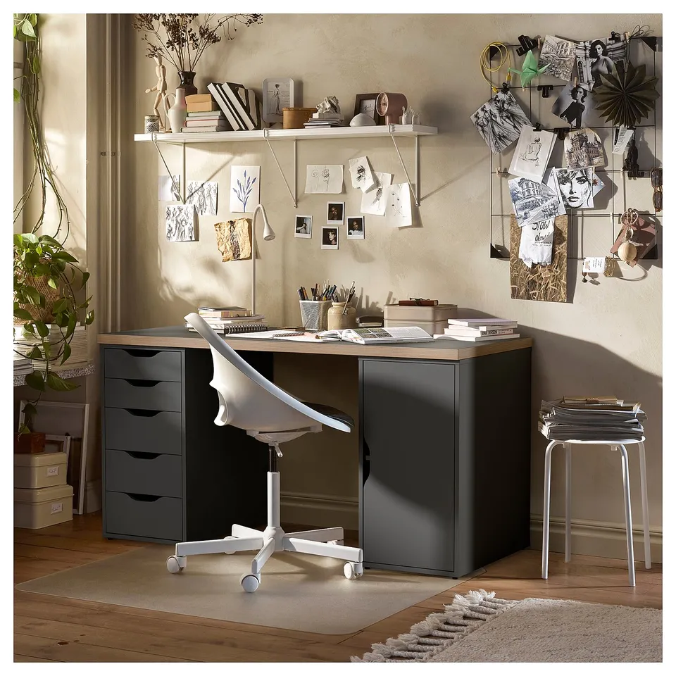 Modern home office setup with black LAGKAPTEN desk, white chair, and shelves adorned with books, plants, and decorations.