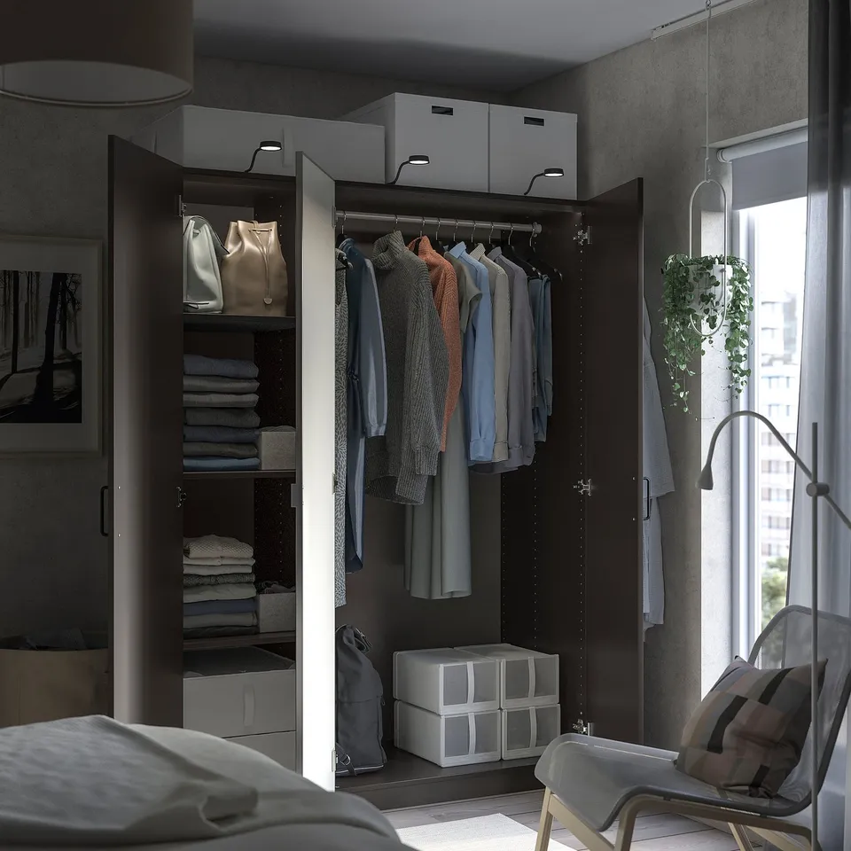 Open wardrobe with clothes, folded clothes, and storage boxes. Modern grey design.