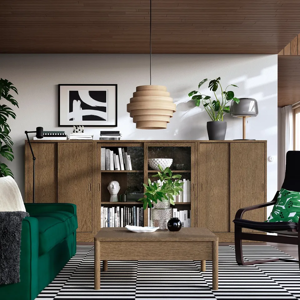 Modern living room with TONSTAD cabinet, green chairs, striped rug, coffee table, and pendant light. Bright natural light.