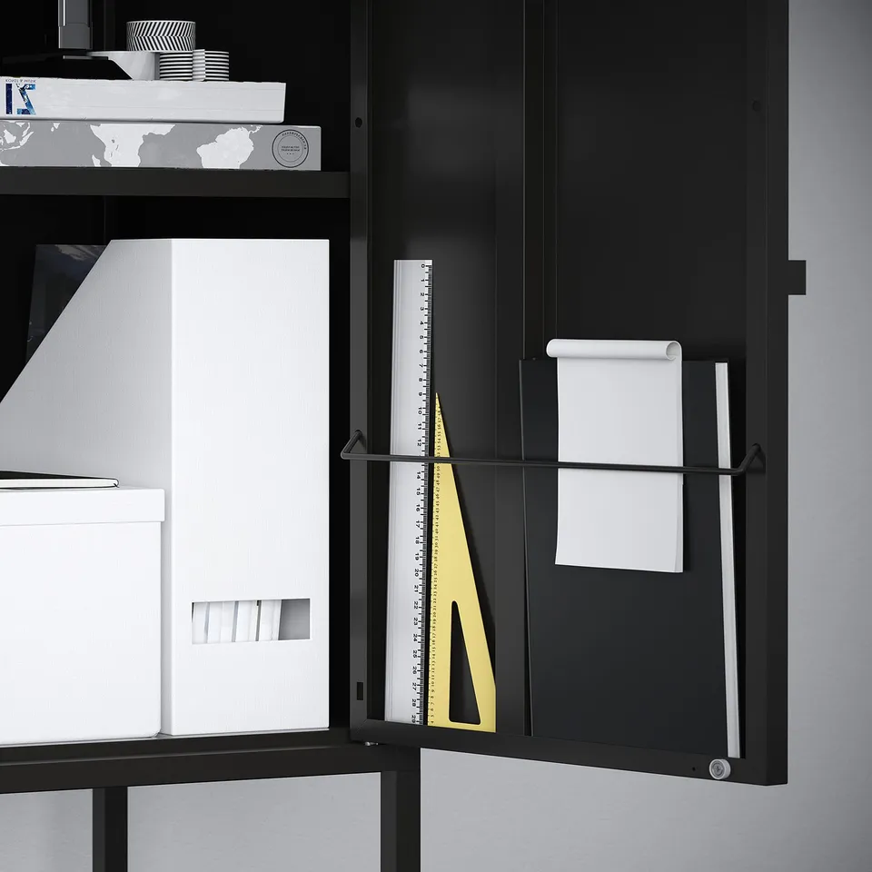 Black storage cabinet with white paper and ruler. Door can be left or right.