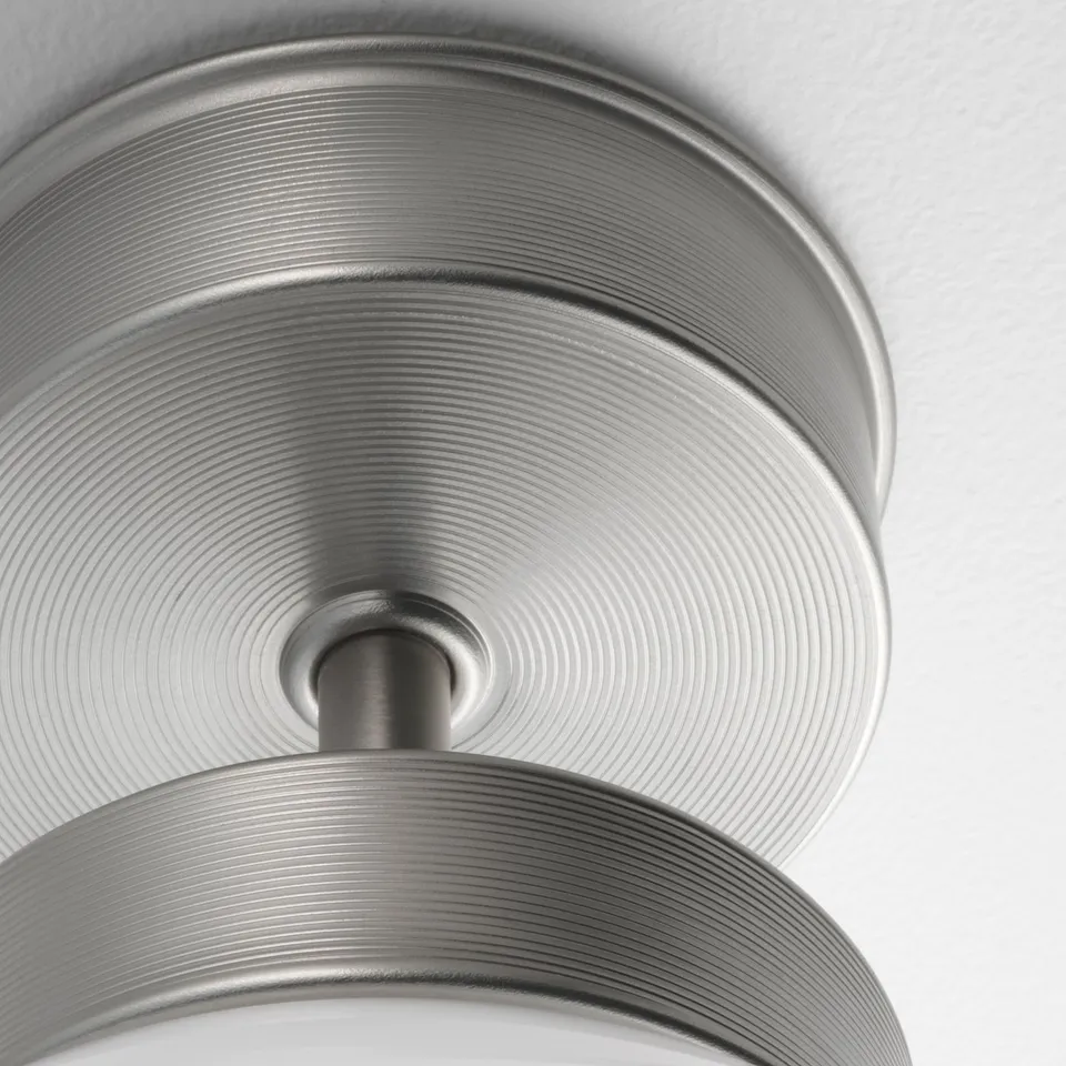 Modern metallic ceiling lamp with intricate ribbed design. Shiny, high-quality finish enhances aesthetic appeal.