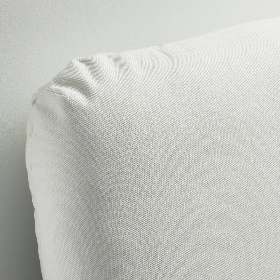 A close-up of a clean, white, upholstered bed frame. The fabric looks smooth and inviting, showcasing a modern and cosy design.