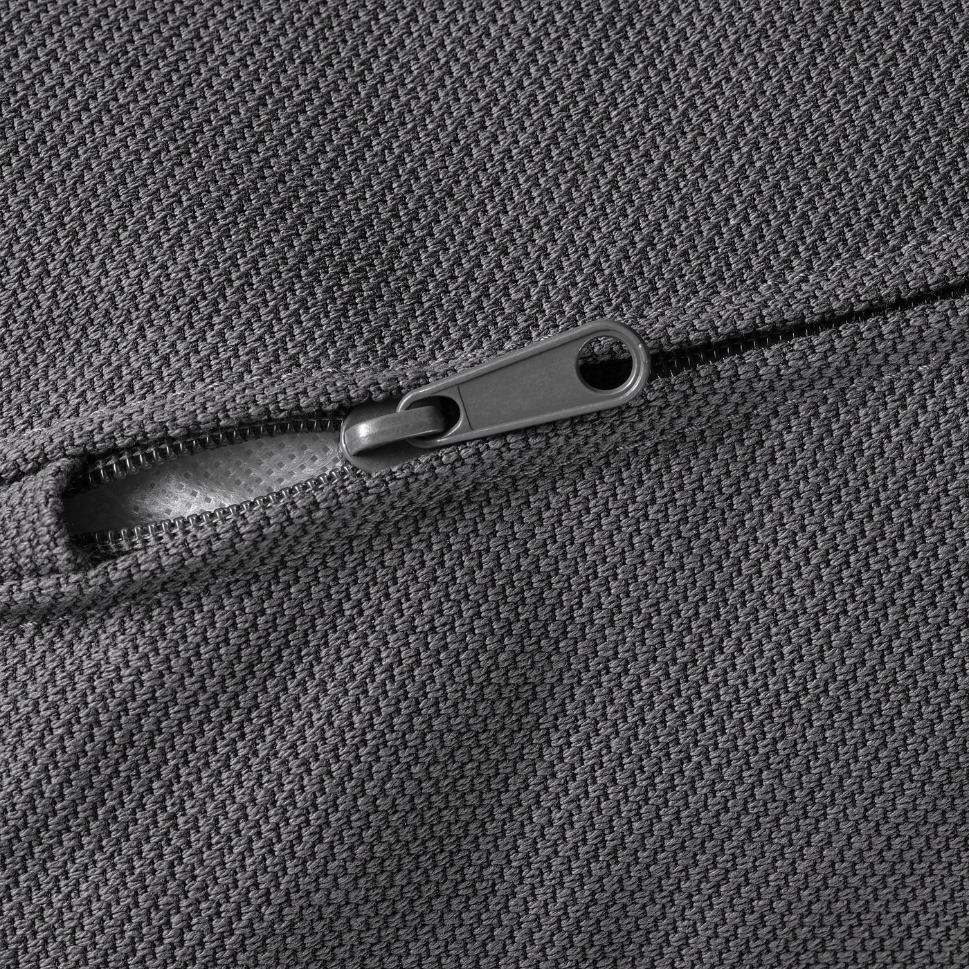 Close-up of high-quality zip on durable, textured fabric sofa.