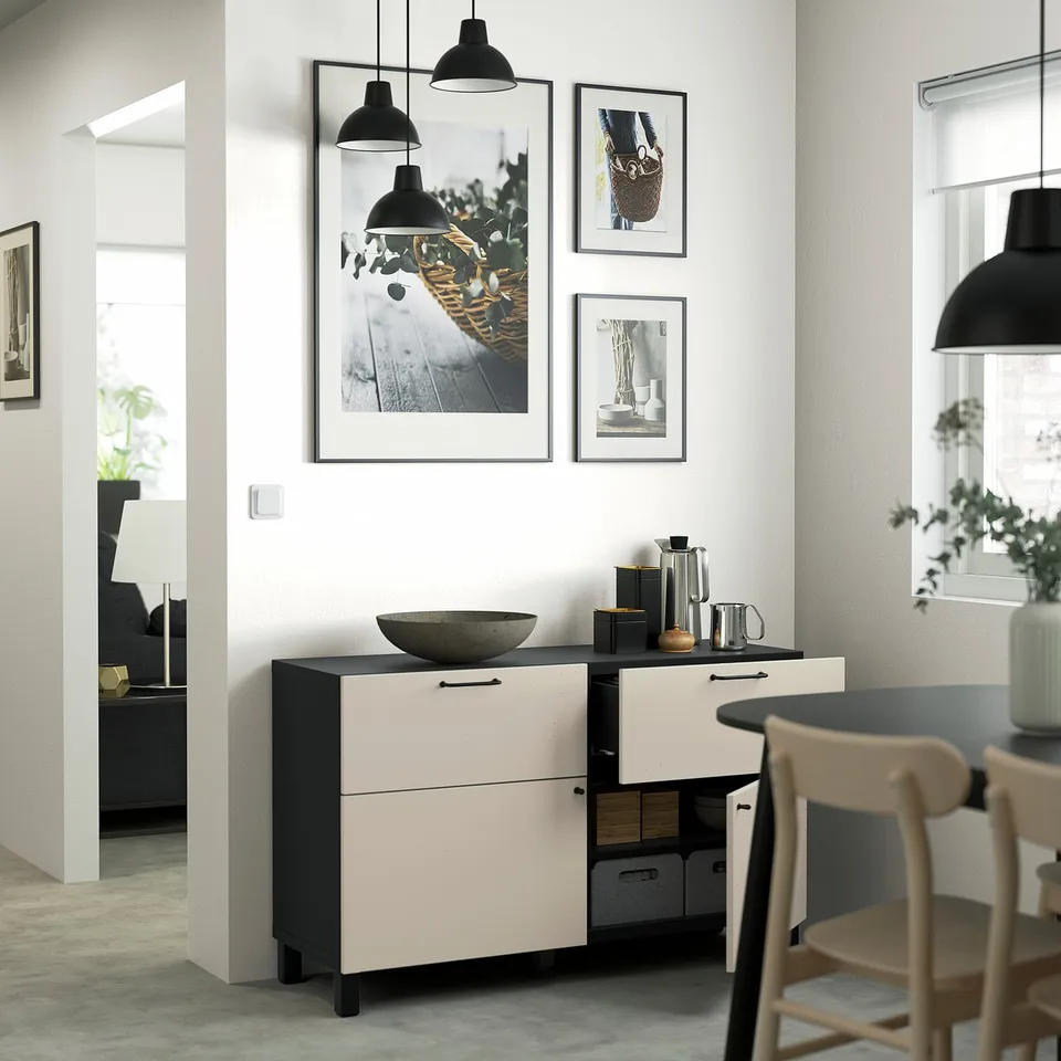 Modern dining area with BESTÅ sideboard. White, black accents, gallery wall. Storage, display, countertop decorations.