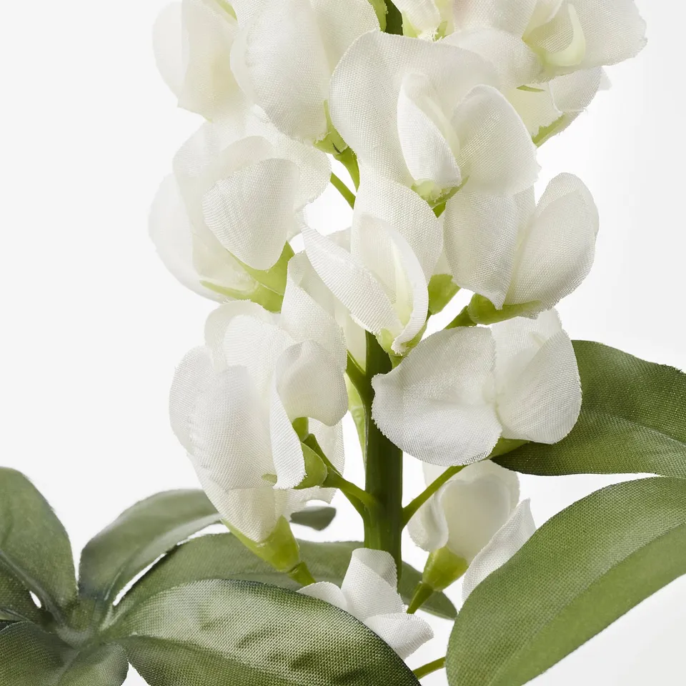 Lifelike white artificial flowers with green leaves, made from recycled materials.