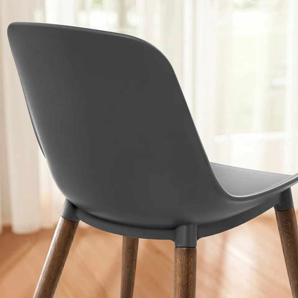 A modern grey chair with smooth curves and wooden legs, designed for comfort.