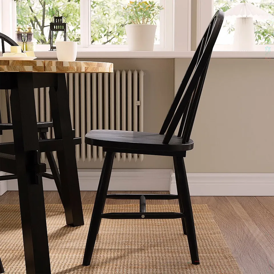 Black wooden SKOGSTA chairs, durable & sturdy acacia, near window & beige radiator.