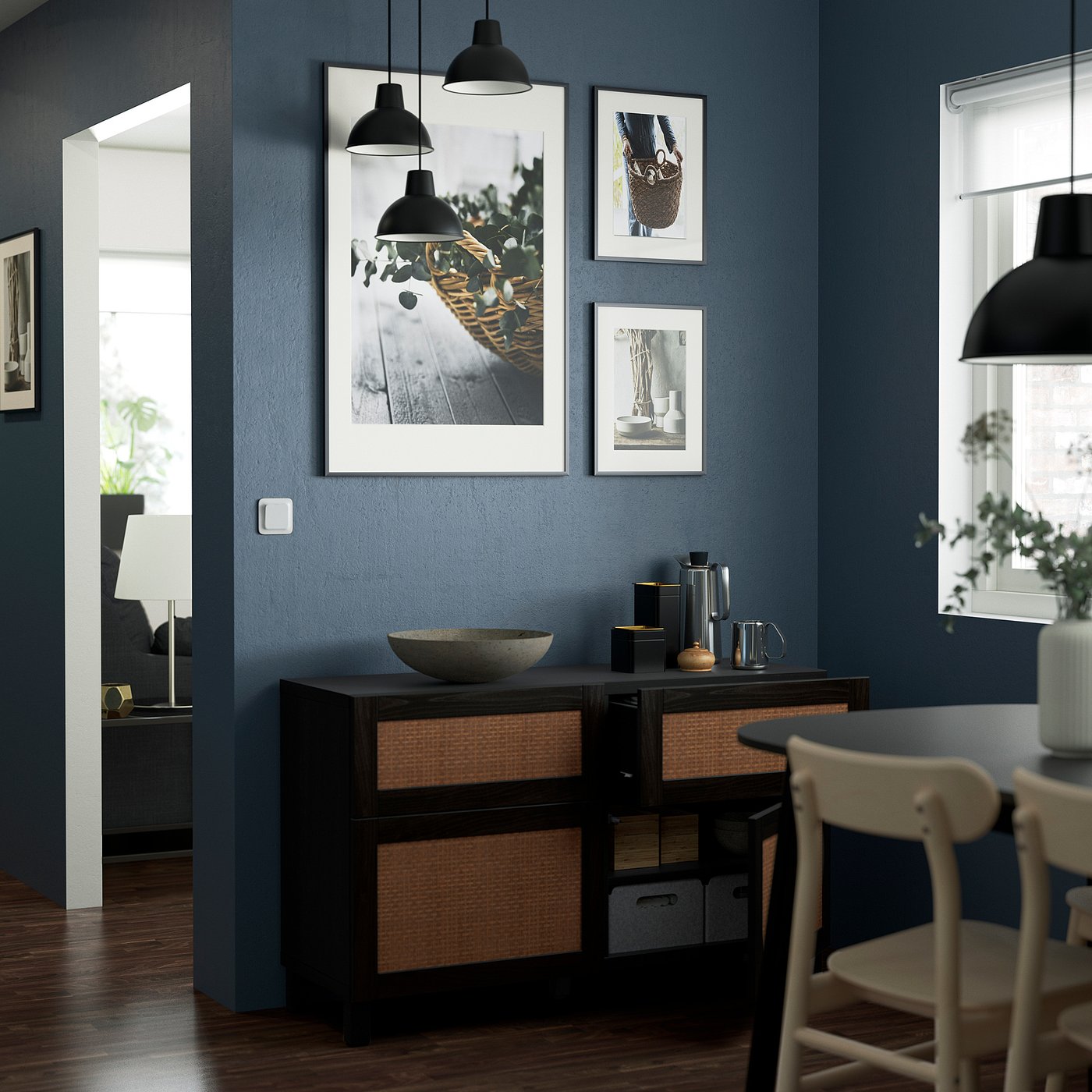 Modern room with dark blue wall, woven sideboard, art, lamps, bowl, and coffee set.