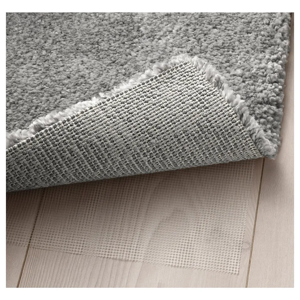 Close-up of plush, soft area rug with anti-slip mesh underside for stability.