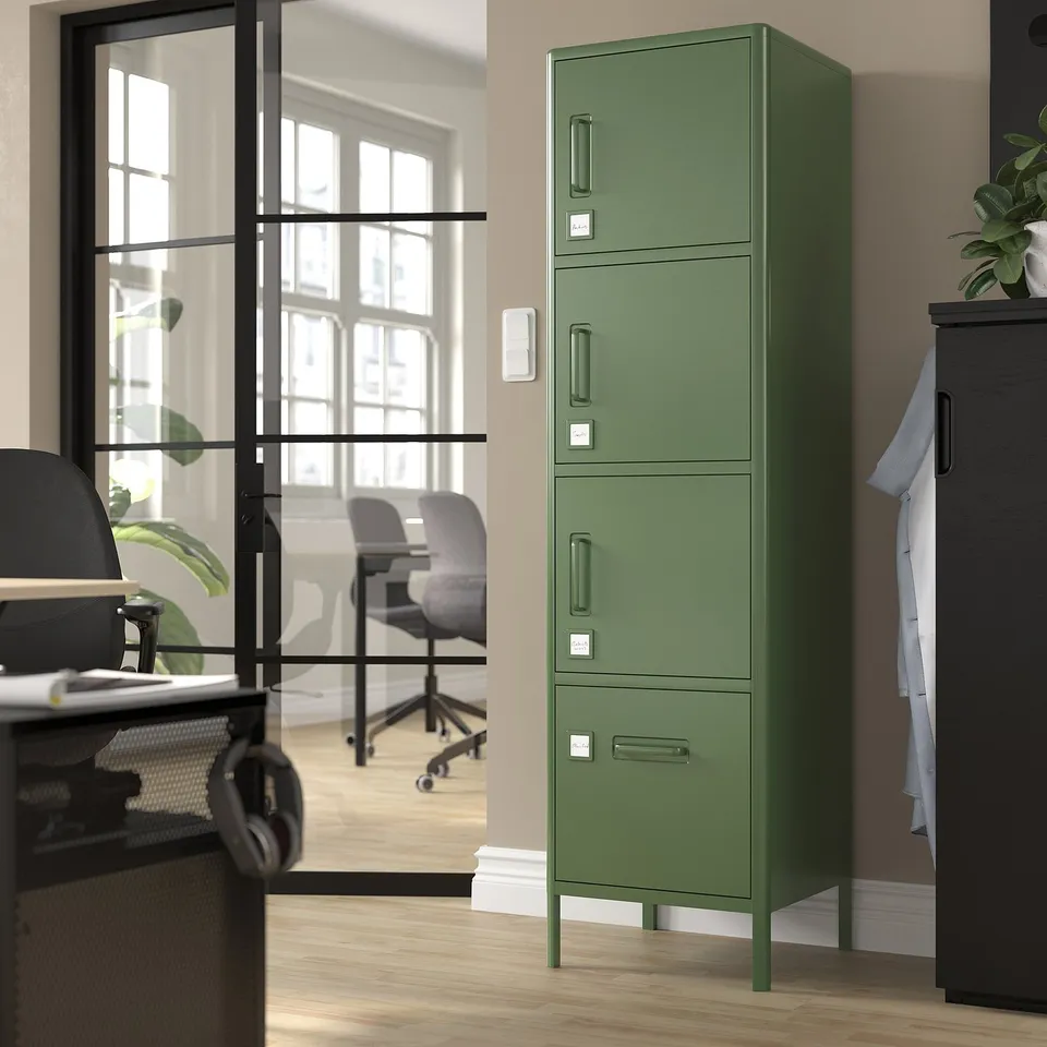 Green metal storage cabinet with multiple compartments in an office.