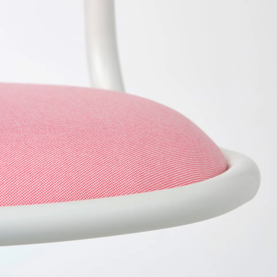 Close-up of a modern, white and pink seating area, showcasing high-quality fabric and durable foam design.