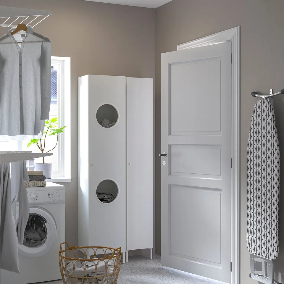 Small white NYSJÖN cabinet near a washing machine in a laundry room.