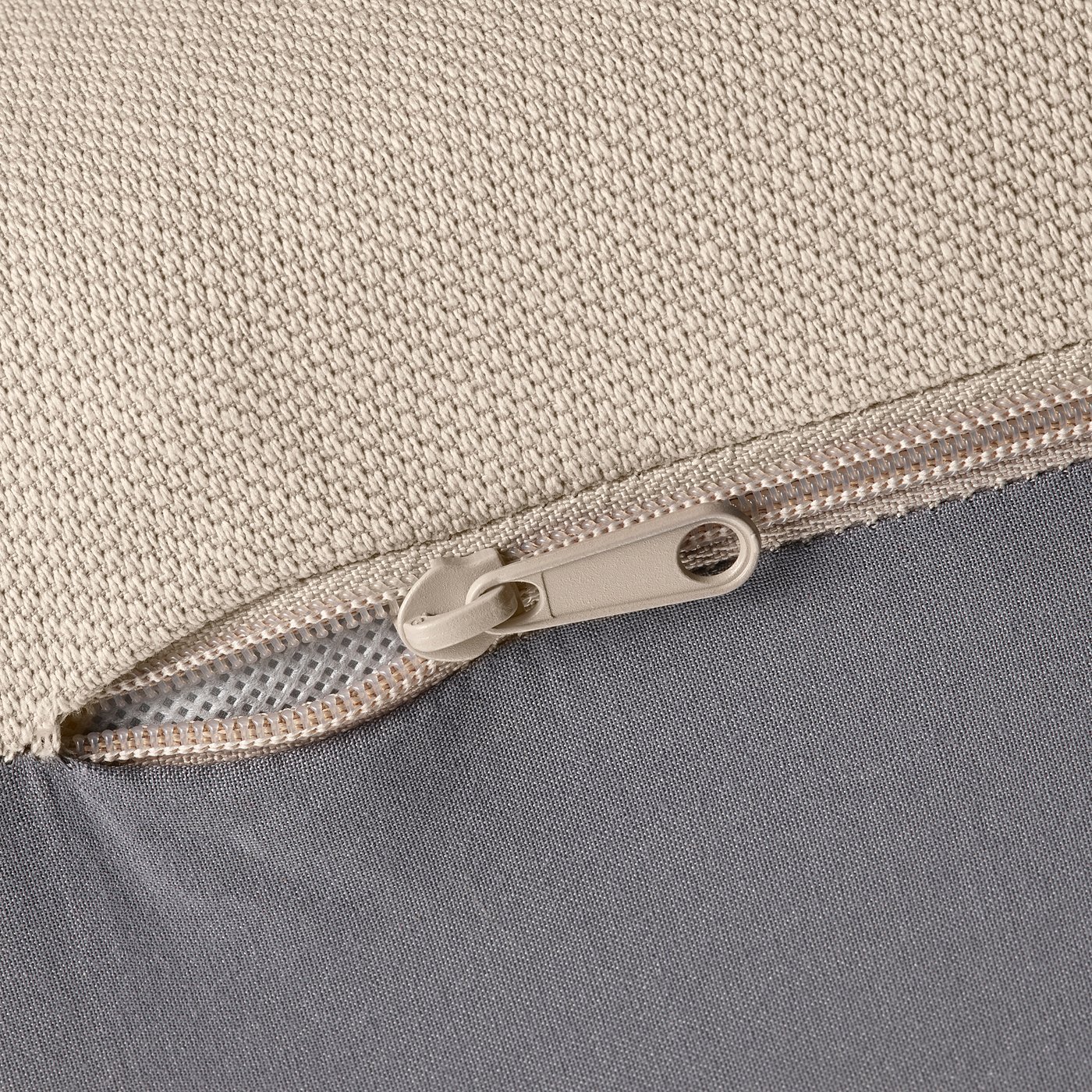 Close-up of zip on beige fabric, showing quality stitching and durable material.