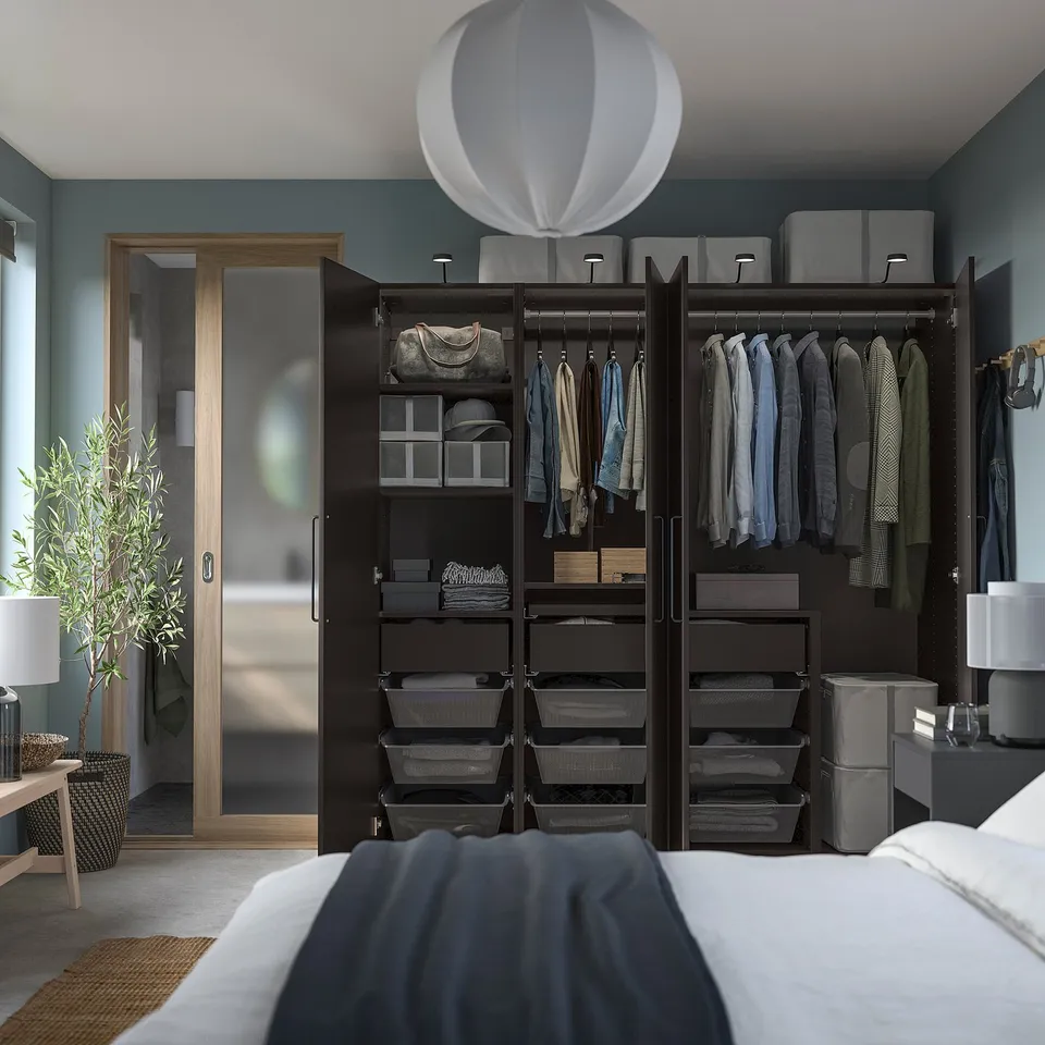 Modern bedroom with a grey PAX wardrobe, featuring clothes and accessories storage, and a white bed.