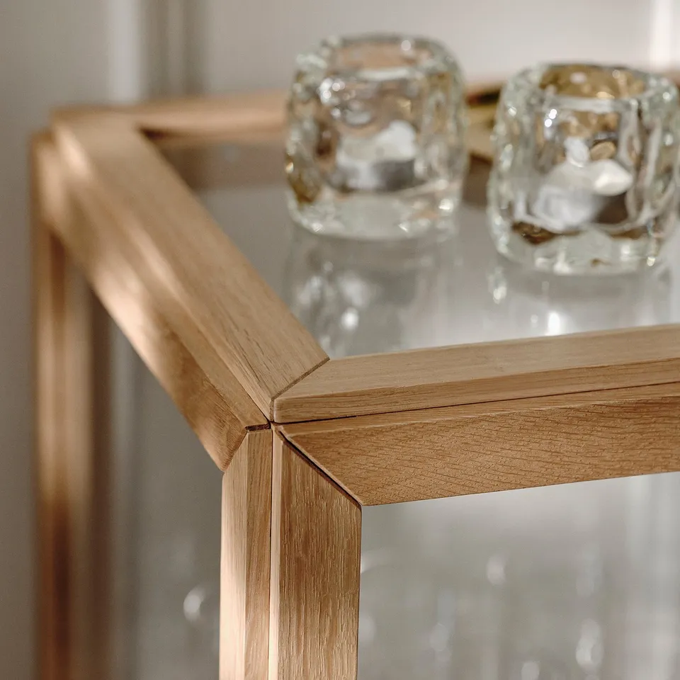 Close-up of high-quality wooden cabinet with clear glass containers. Craftsmanship and detail.