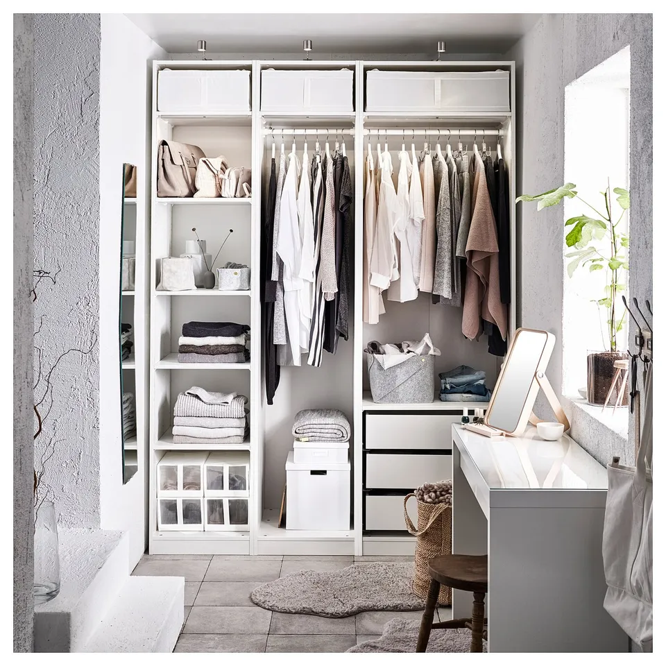 Neat closet with PAX system, shelves, hanging space, and bins. Neutral clothes and plants.