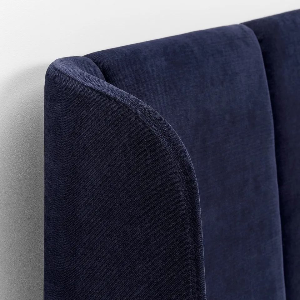 Deep blue bed frame, soft velvety texture. Curved headboard, refined stitching.