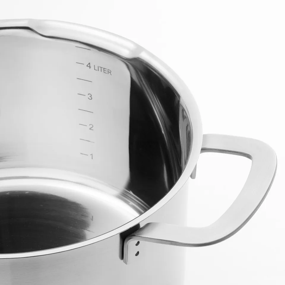 Close-up of stainless steel pots handle and lid. High-quality, induction compatible, with heat-resistant glass lid and spout for easy pouring.