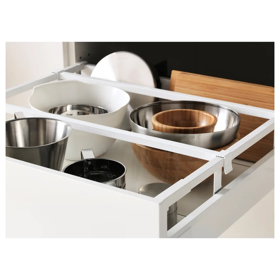 Open kitchen drawer with organised utensils and bowls.