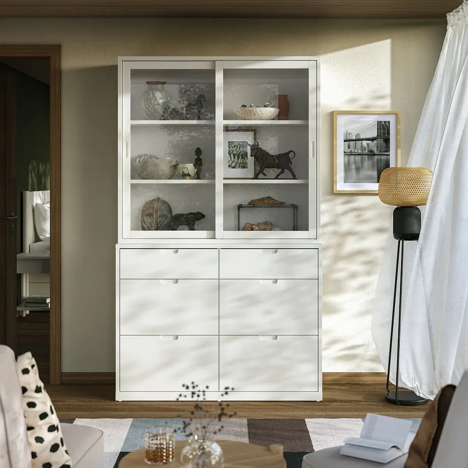 Modern living room with white cabinet displaying art, and stylish lamp.