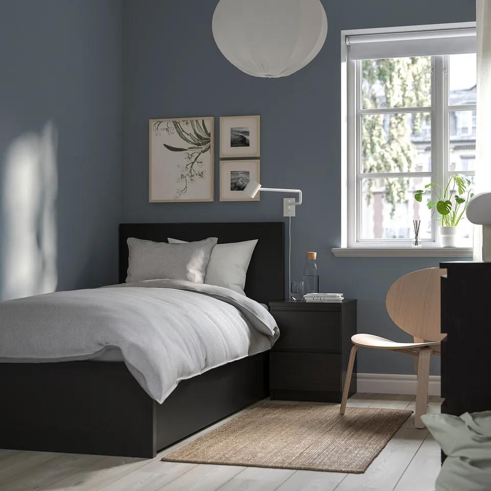 Modern bedroom with black MALM bed, minimal bedside table, art, and large window.