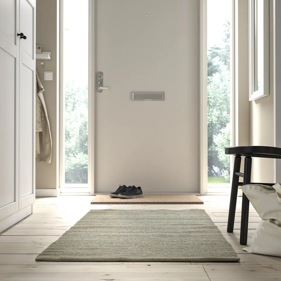 Minimalist entryway with TIDTABELL rug, adding texture and functionality.