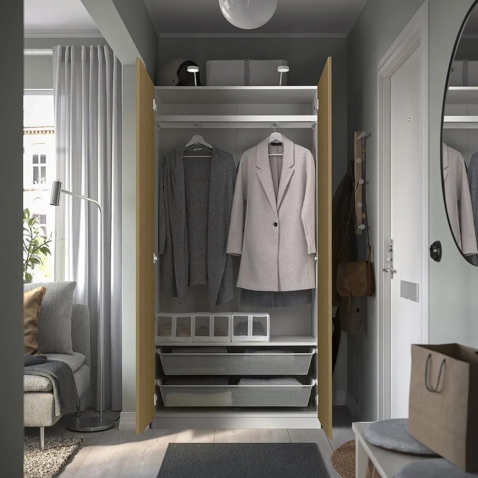 Modern closet with organised drawers, hanging jackets, and bannisters, featuring integrated lighting.