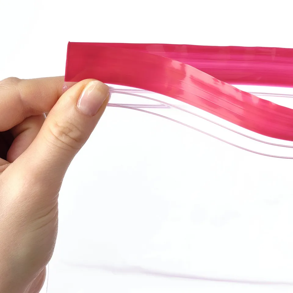 A hand holds a pink reusable storage bag, showcasing its sealable feature. Ideal for organising and keeping contents fresh.