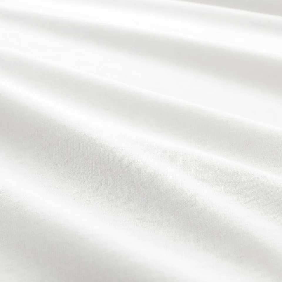 Close-up of soft, white cotton jersey fabric, showcasing its smooth texture and slight stretch.
