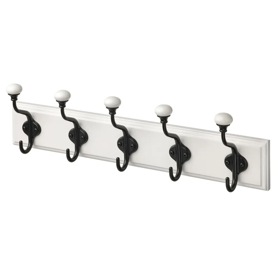 A white LANDKRABBA wall-mounted rack with five pairs of black double hooks featuring porcelain knobs.