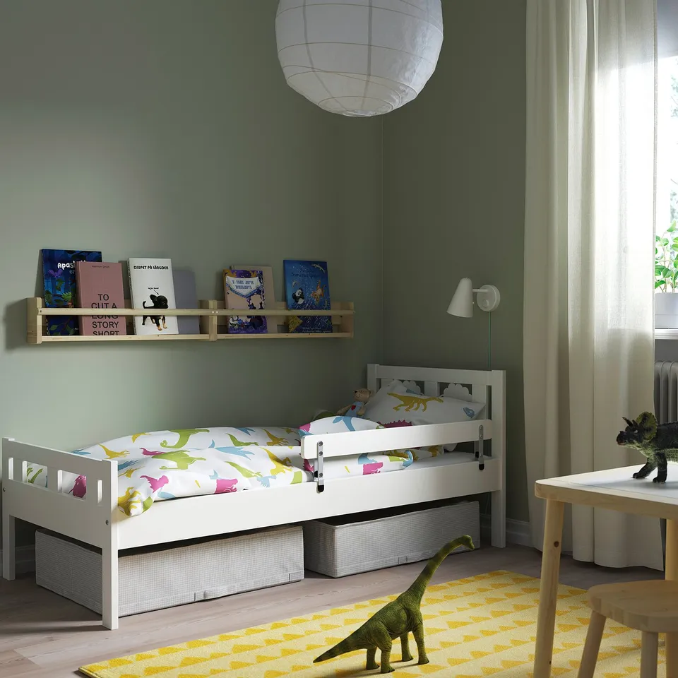 Childrens bedroom with KRITTER bed, dinosaur bedding, bookshelf, large dinosaur toy on rug.