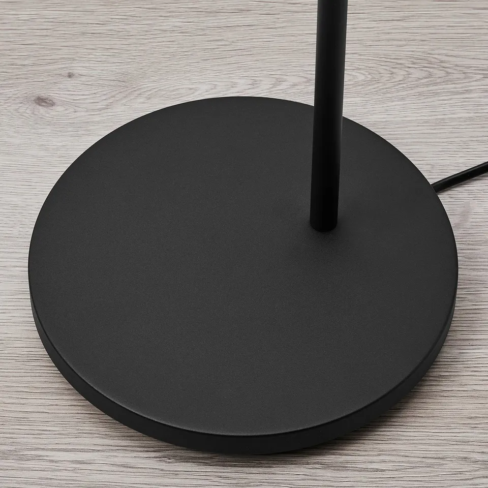 Modern black floor lamp with round base and flexible neck, for directional reading light.