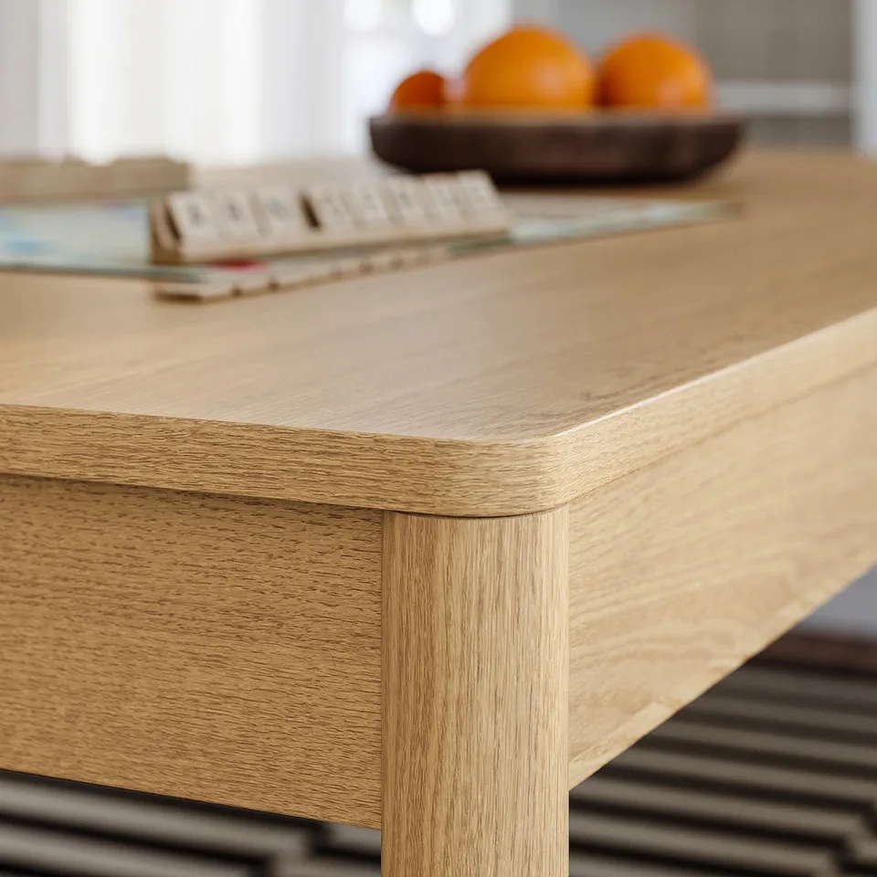 Wooden table with smooth edges. Visible grain pattern, modern design. Fruits in bowl on top.