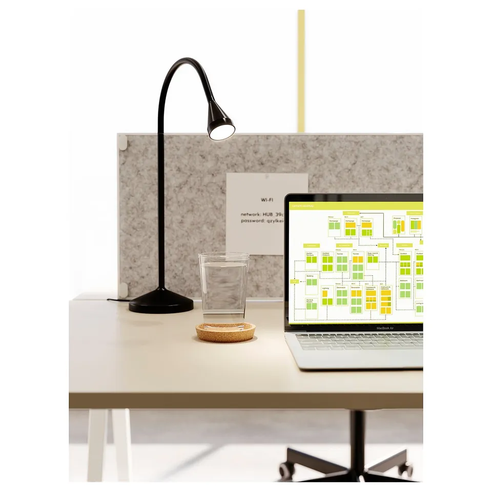 Minimalist black desk lamp, adjustable neck, led light, near a laptop, glass, and notes.